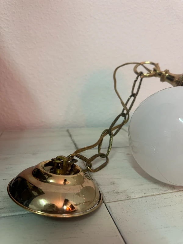 Chandelier hanging from brass chain, full length