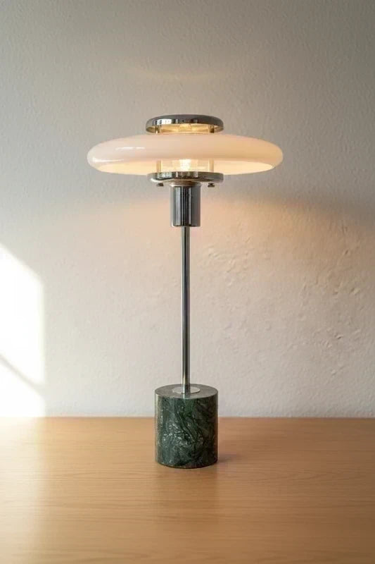 UFO table lamp lit on white wall, full view
