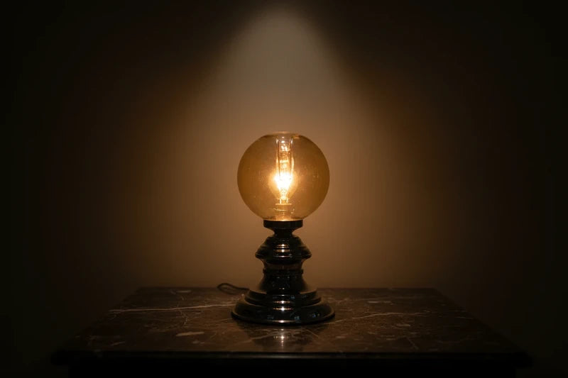 Amber globe lamp aan in het donker — warm gouden gloed